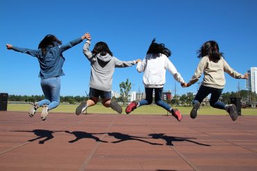 Kids holding hands jumping for joy